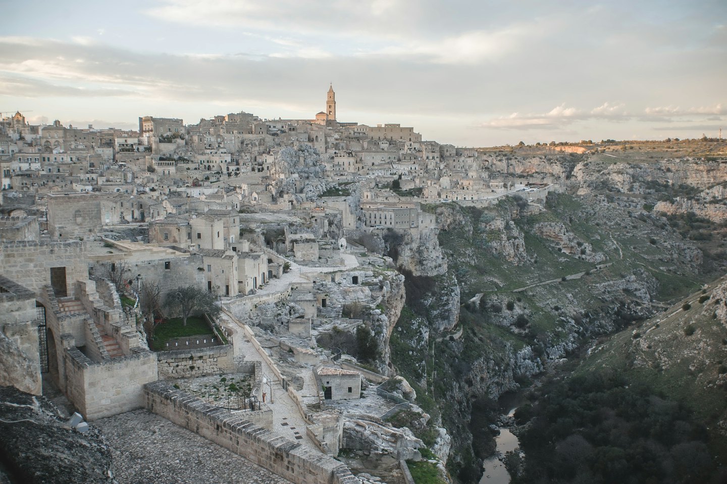 Antica città di pietra costruita in un canyon roccioso con un fiume.