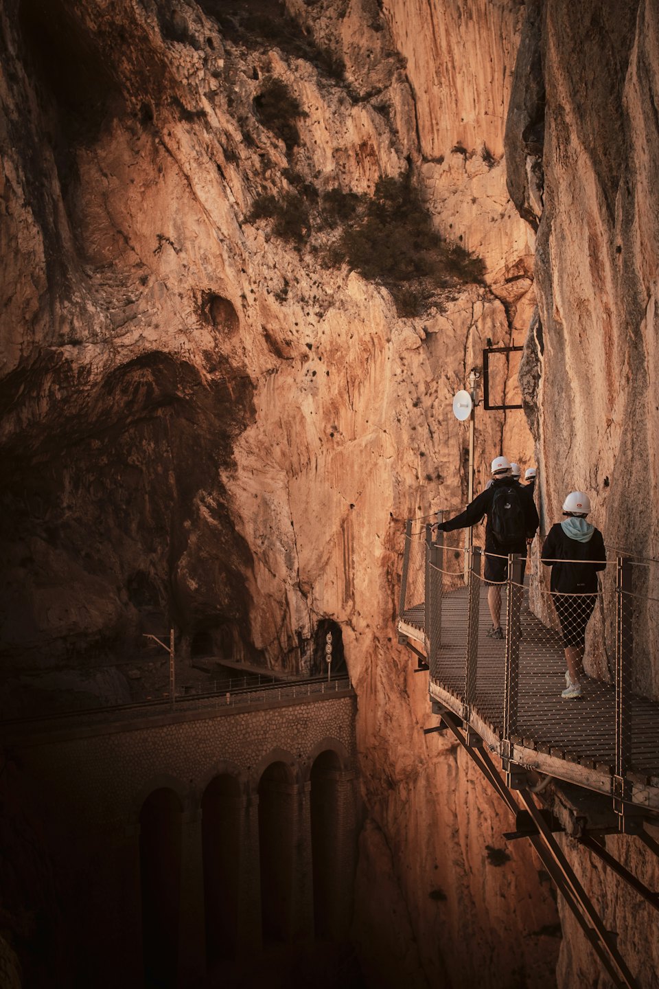 Due escursionisti percorrono uno stretto sentiero a picco sul canyon.